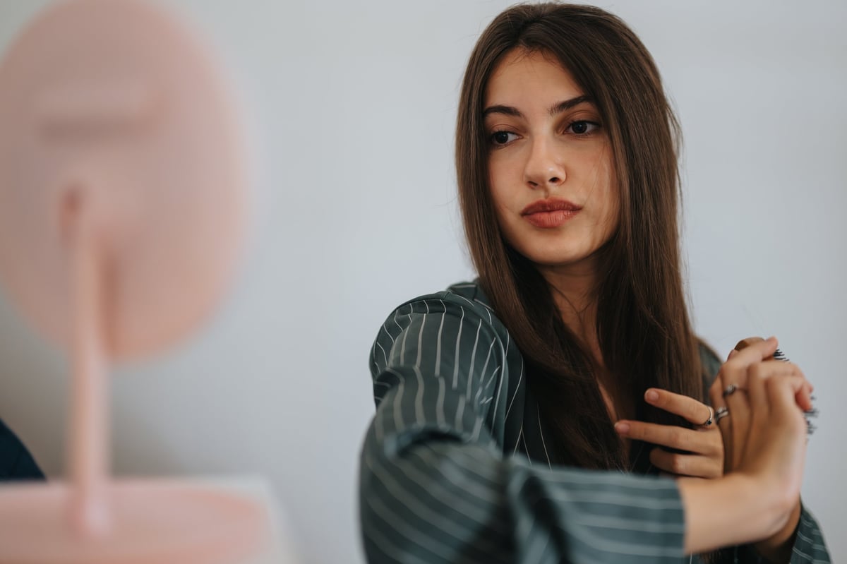 Persona contemplando su reflejo mientras elementos de salud se conectan a su alrededor: concepto de transformación holística